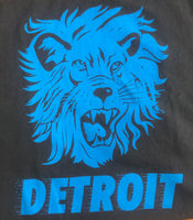 Close-up of charcoal gray Detroit tee with large blue lion face design