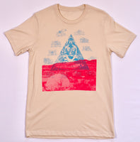 Light tan t-shirt featuring a blue pyramid design with a seated meditating figure inside, surrounded by celestial symbols and neon pink abstract shapes