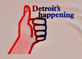 Close-up of vintage-style cream T-shirt featuring Detroit's Happening text and a red to blue ombre thumbs-up graphic